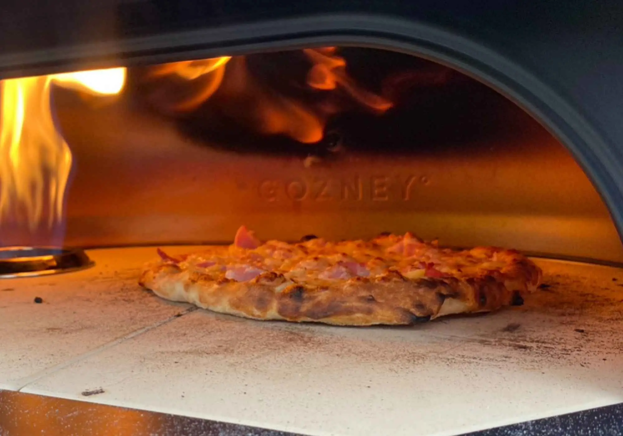 A pizza cooking in the wood-fired oven at Kayanara.